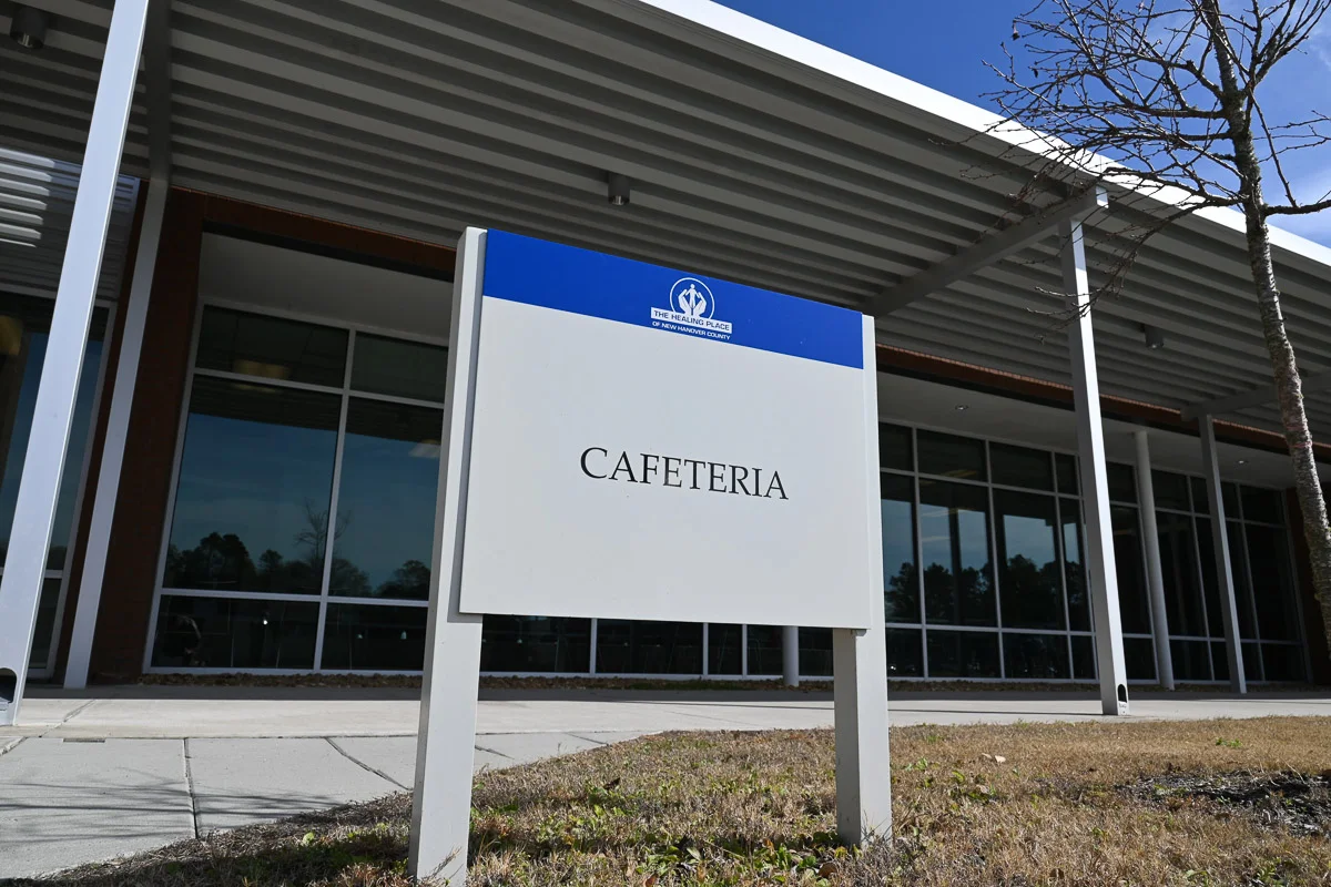 Exterior of cafeteria building with large windows and sign