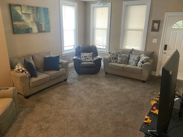 Carpeted lounge with armchairs and natural light