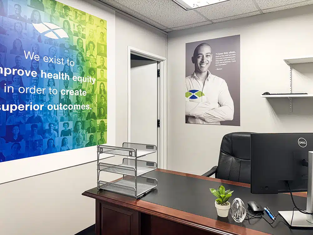 Office desk with computer and health equity wall mural