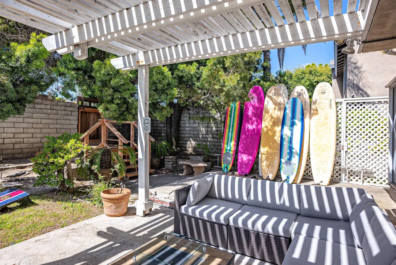 Covered patio with sectional seating and surfboards