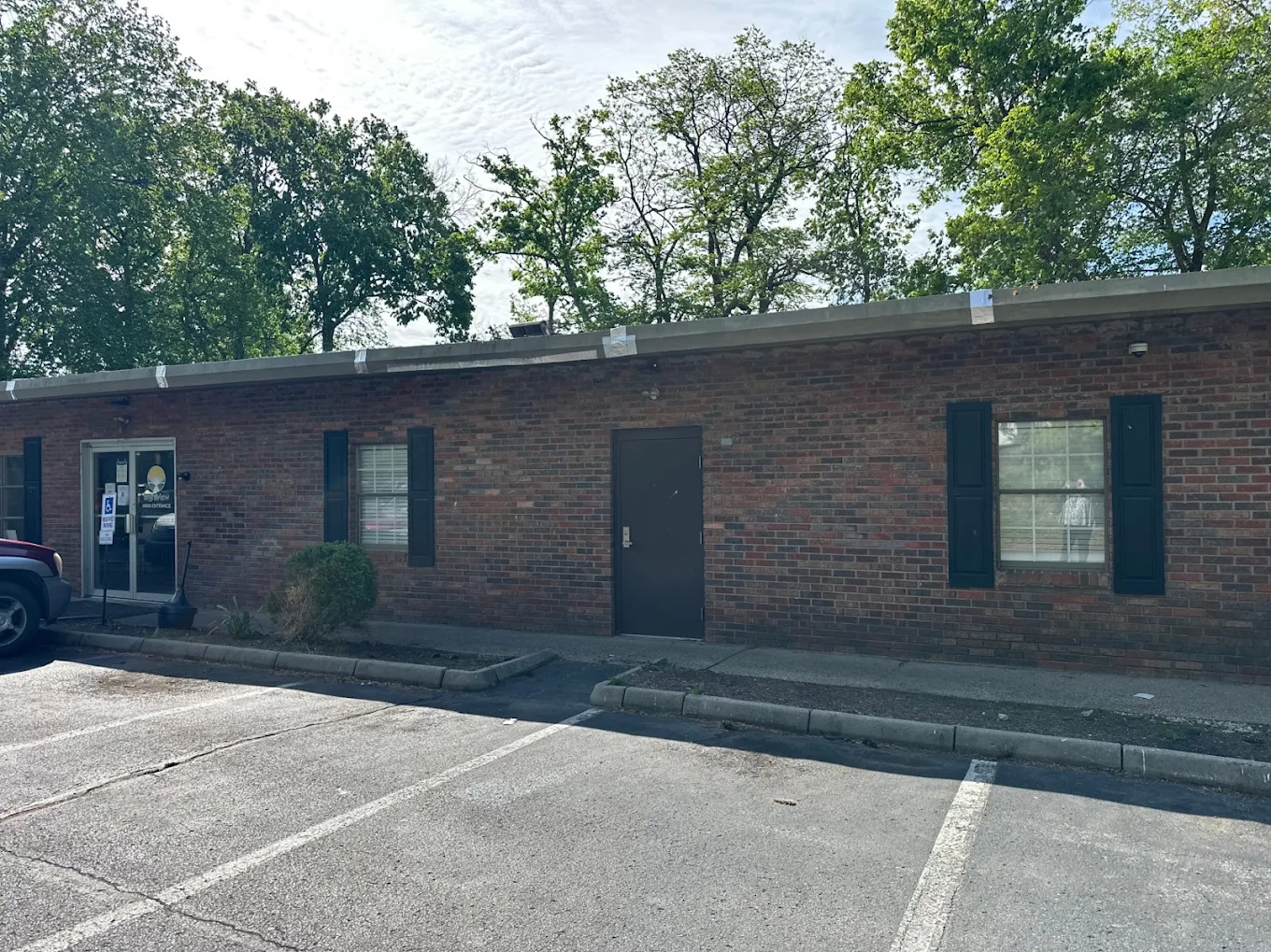 Brick facility entrance with accessible parking spaces