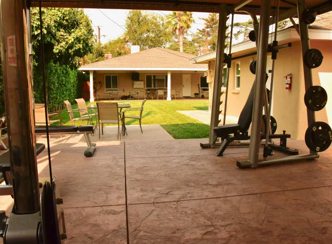 Covered gym area with weights and cardio equipment