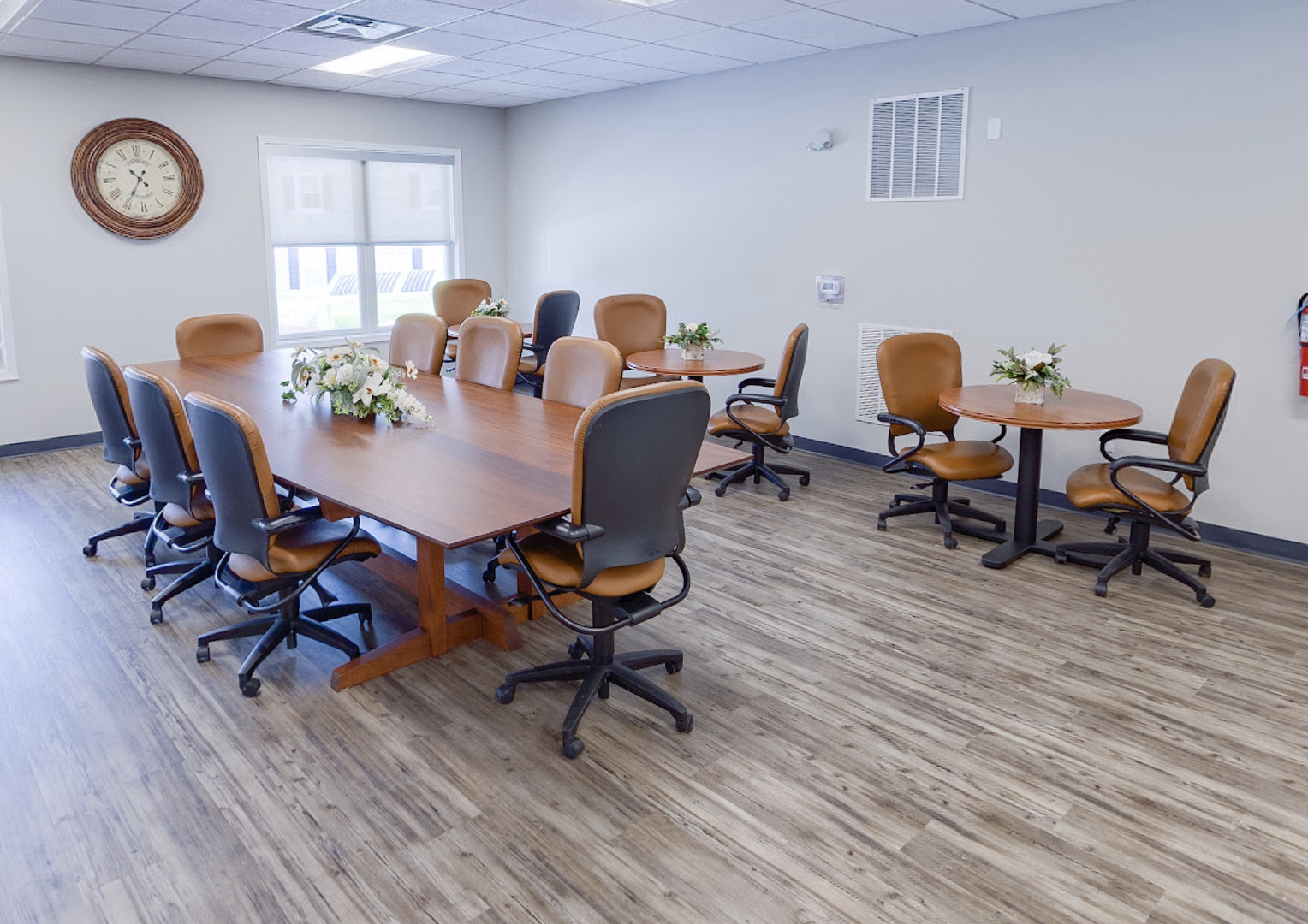 Meeting room with large wooden table and smaller seating areas