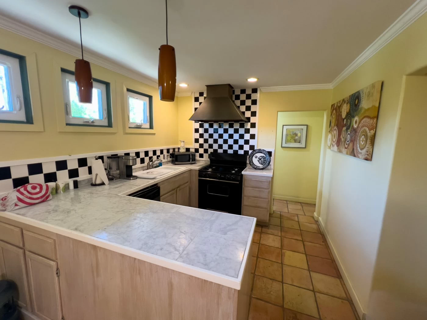 Kitchen with marble counters and black checkered backsplash
