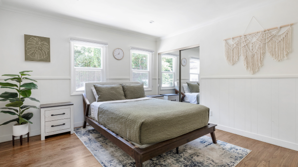 Modern bedroom with queen bed, rug, and natural light