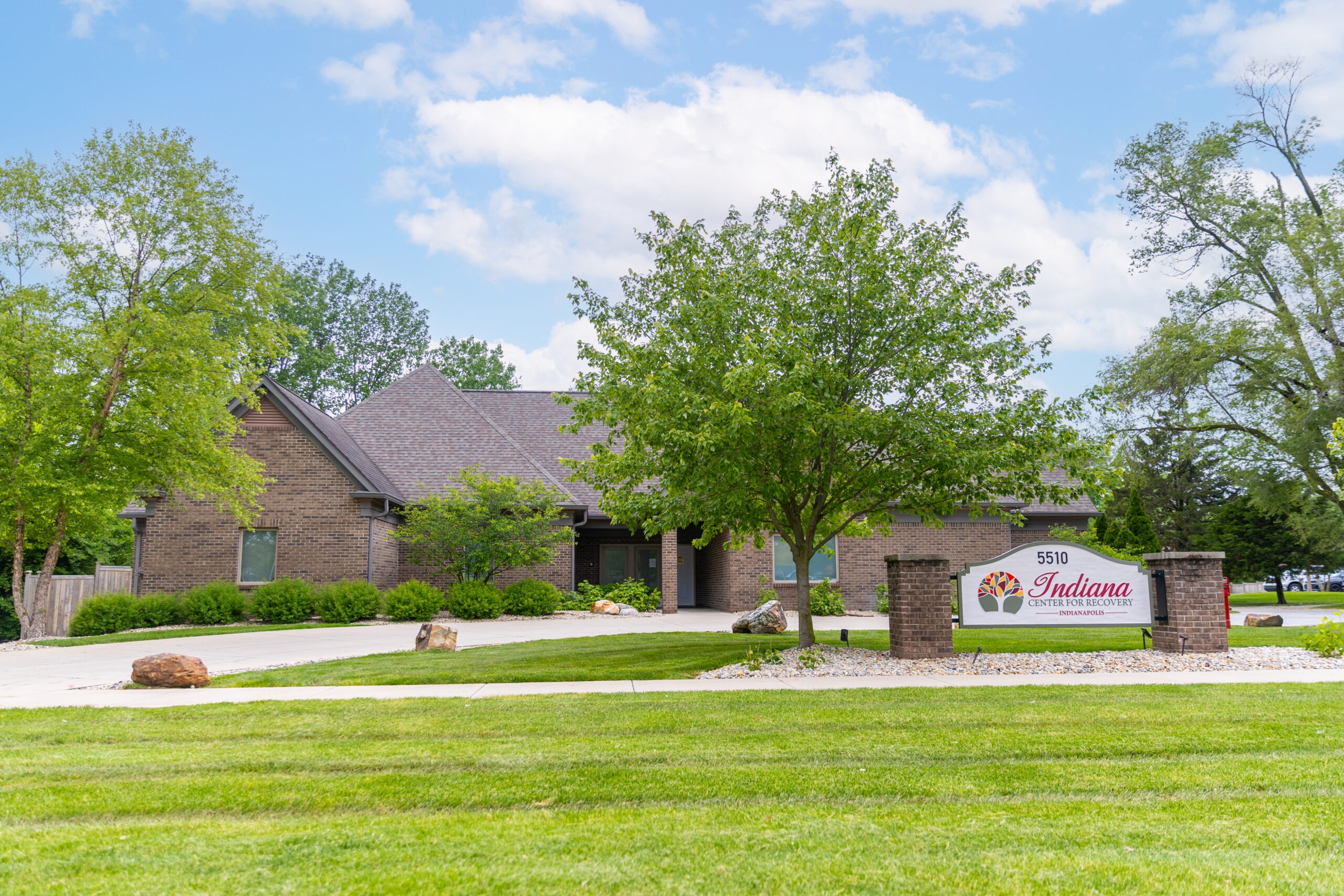 Brick treatment facility with front sign and landscaped lawn.