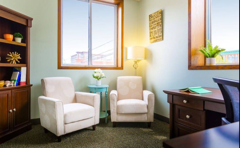 Private counseling office with chairs and desk by window