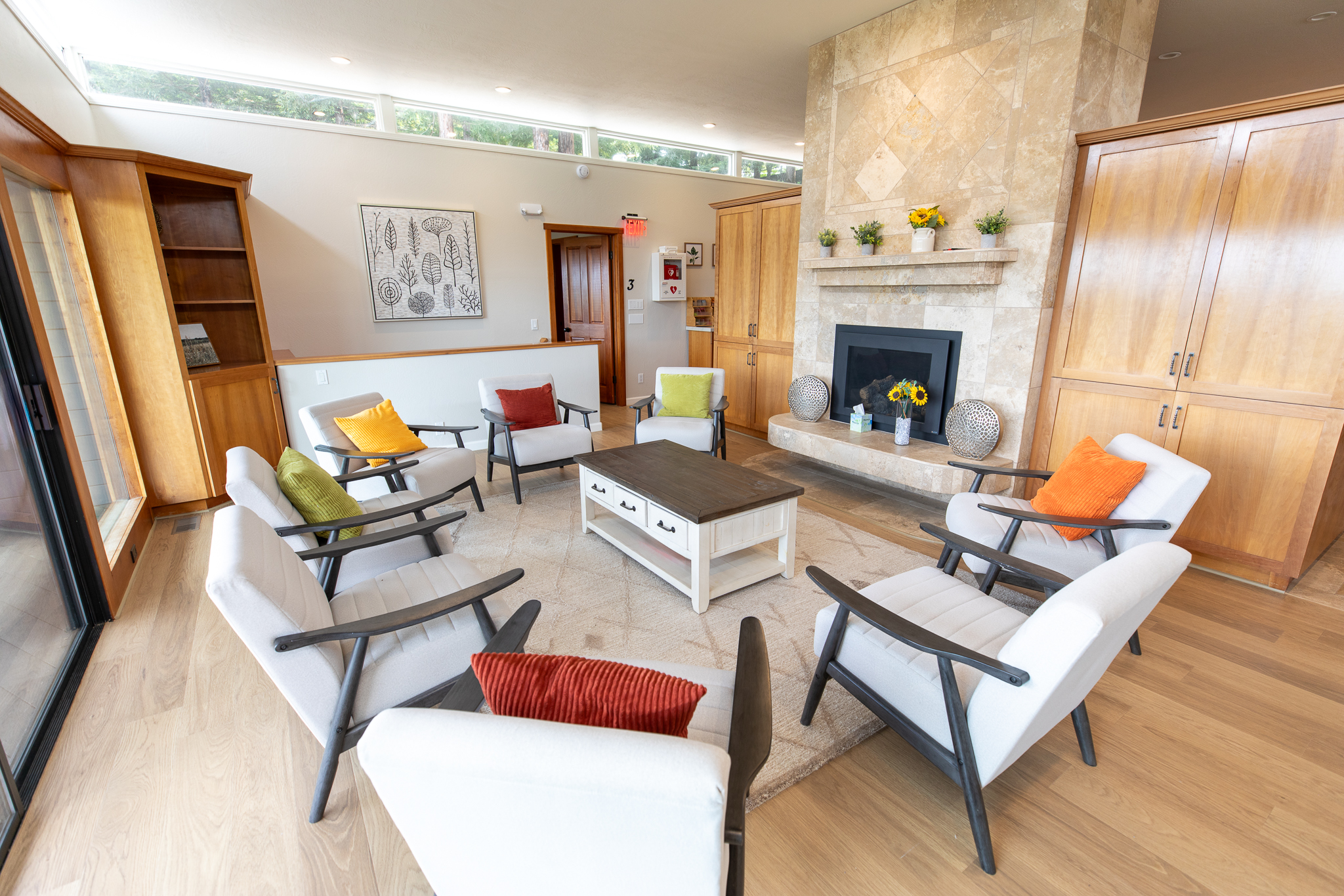 Group therapy room with chairs arranged around a fireplace