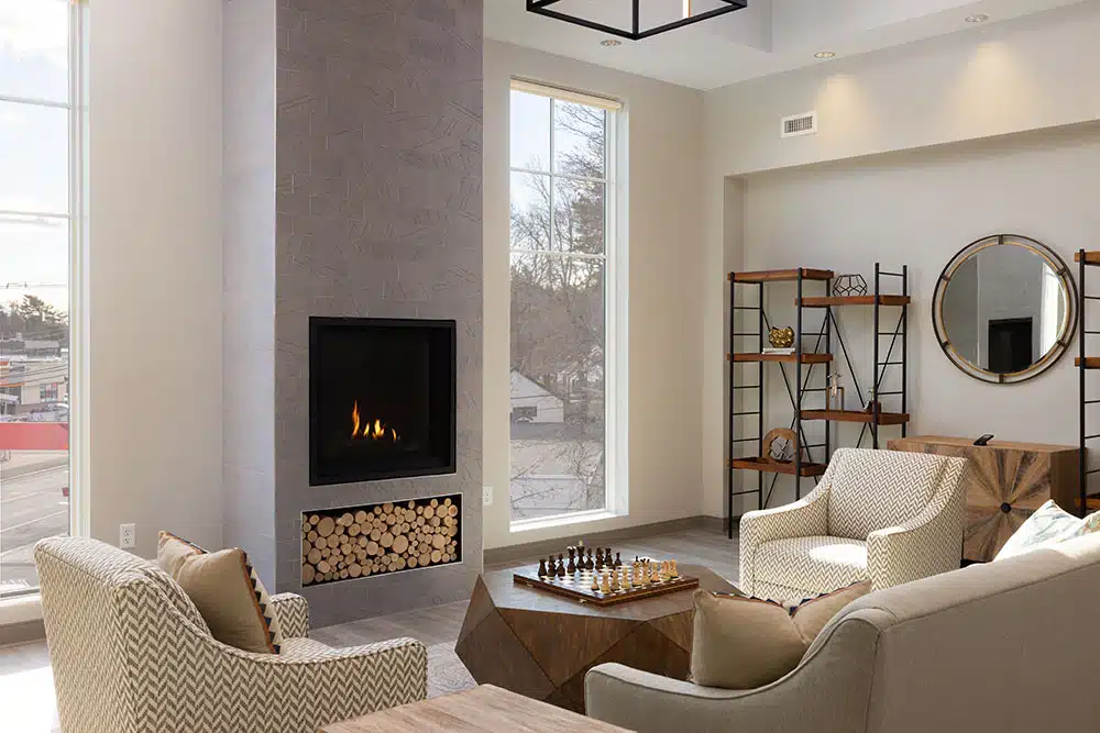 Cozy lounge with fireplace, chairs, and chess table