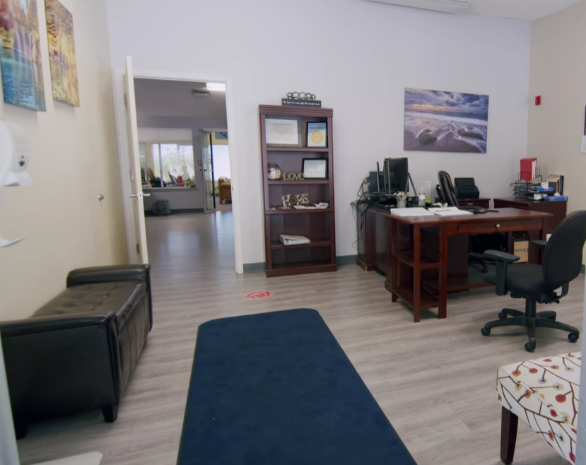 Office with desk, computer, bookshelf, and framed artwork