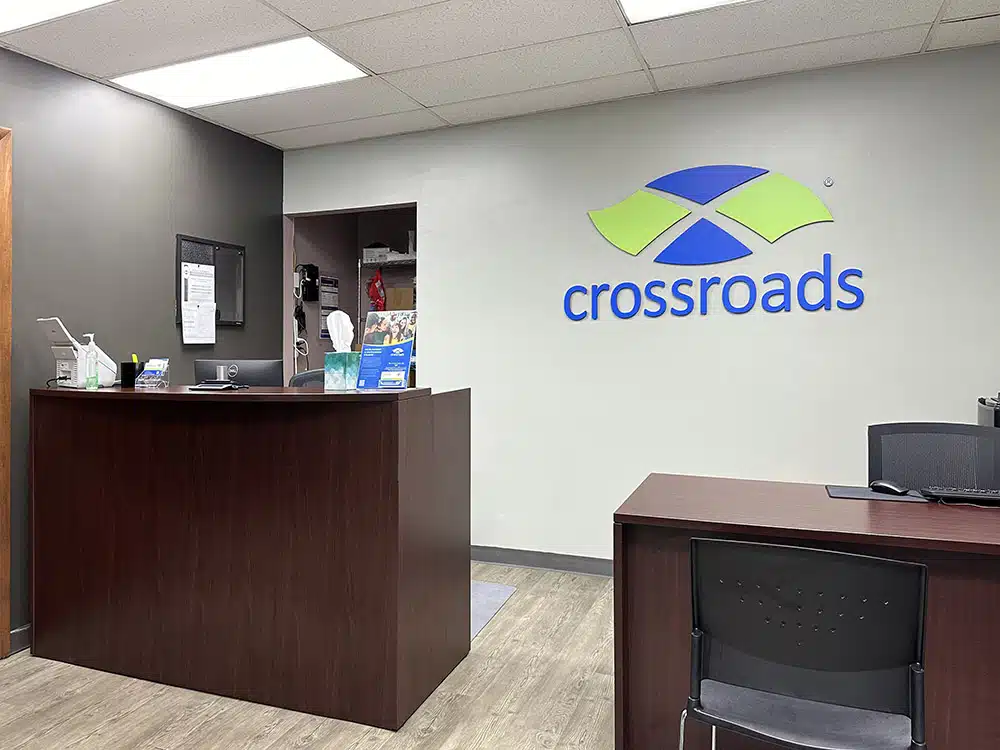 Front desk with Crossroads logo on wall behind reception