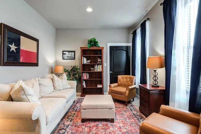 Comfortable lounge with sofa, chairs, and bookshelf