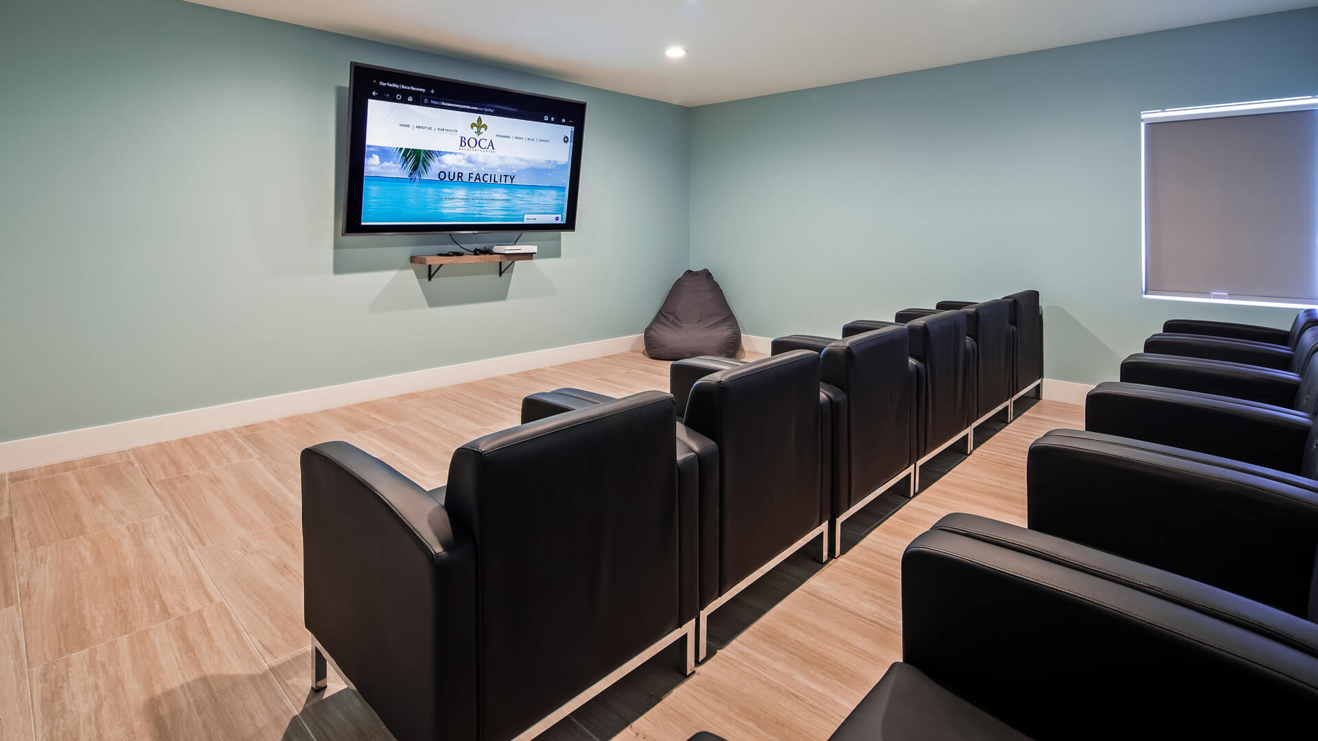 Theater room with black chairs and a screen.