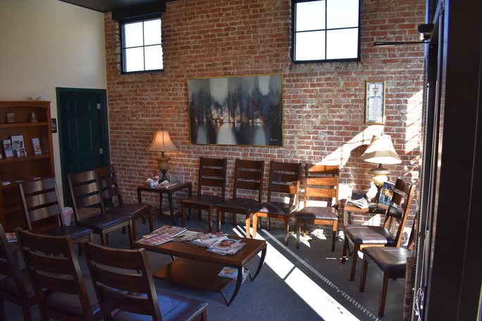 Waiting room with chairs, brick walls, and natural light