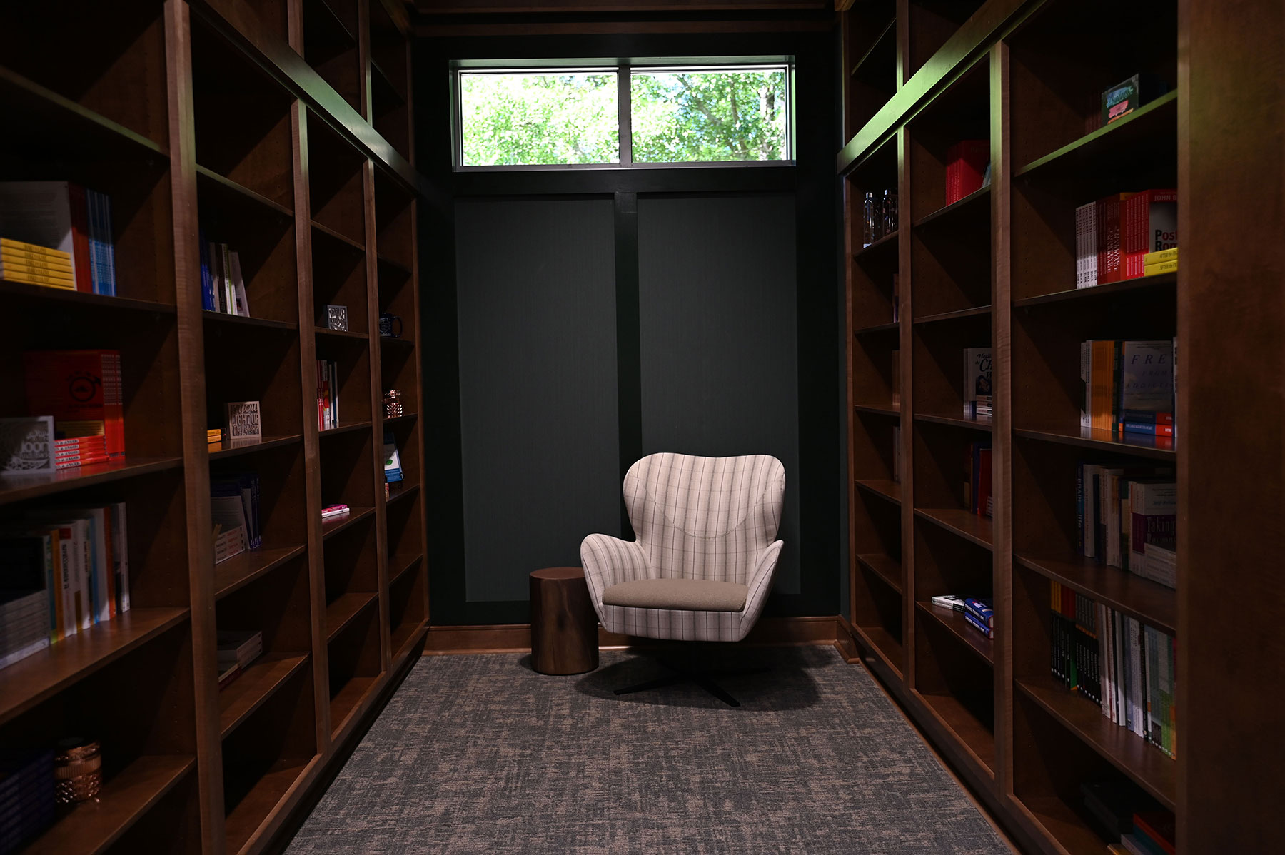 Library with wooden bookshelves and a cushioned armchair