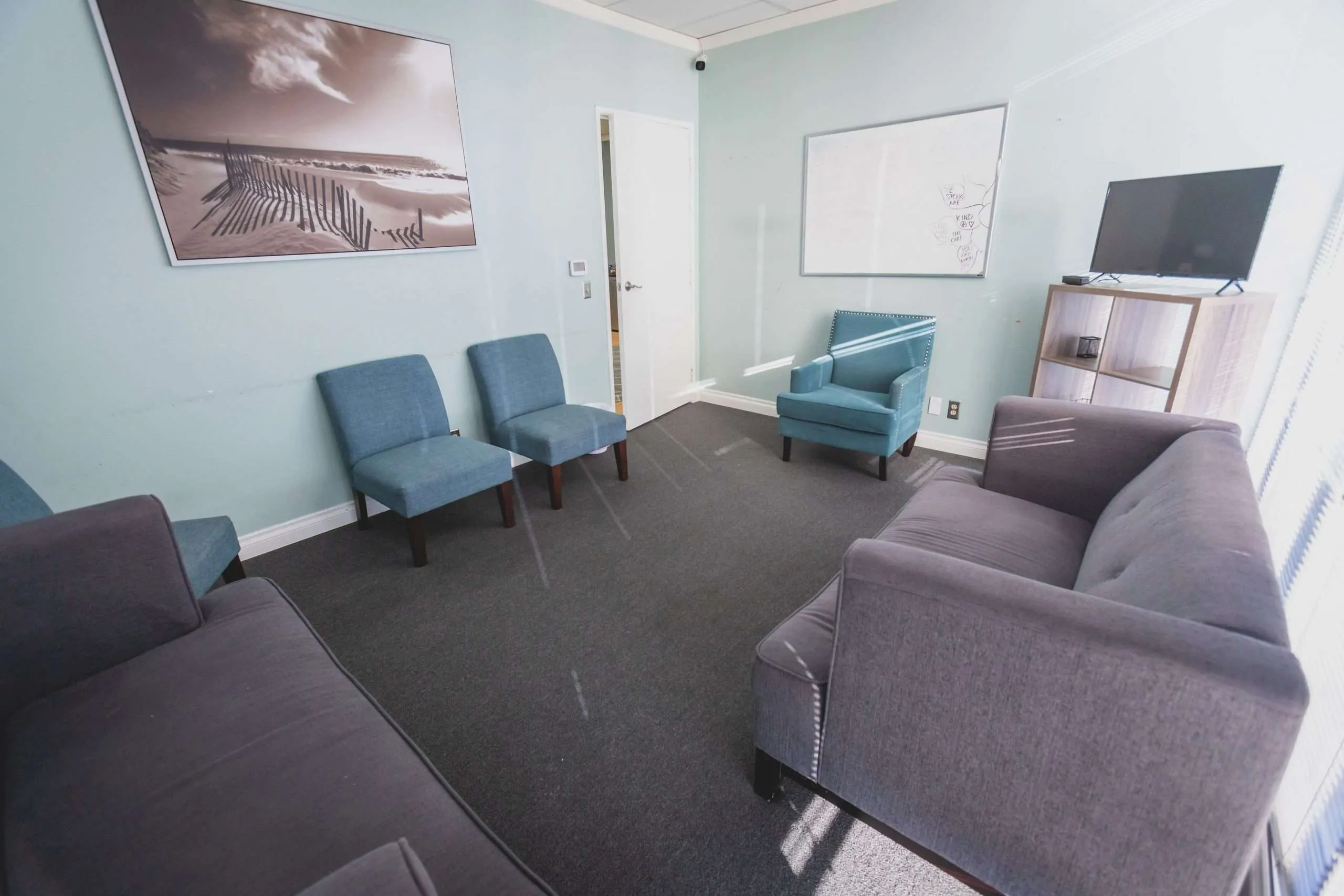 Therapy room with sofas, chairs, and calming wall art