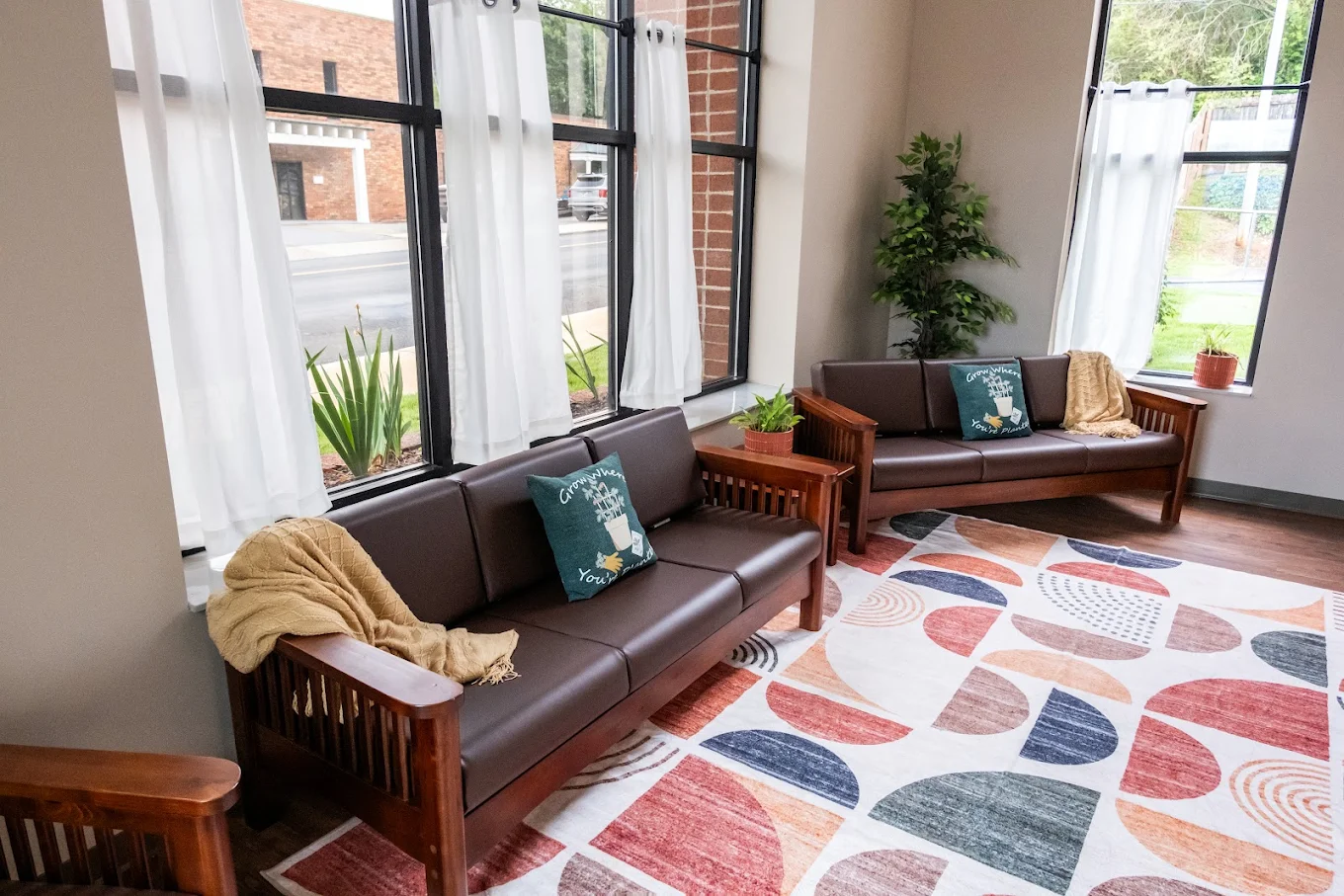 Sunlit waiting area with sofas and large windows