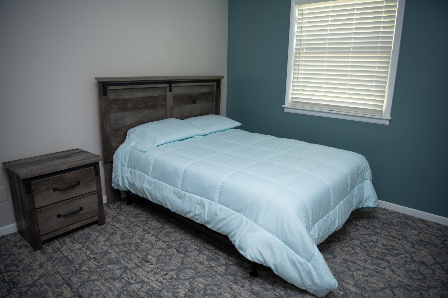 Full-size bed with wood headboard and matching nightstand