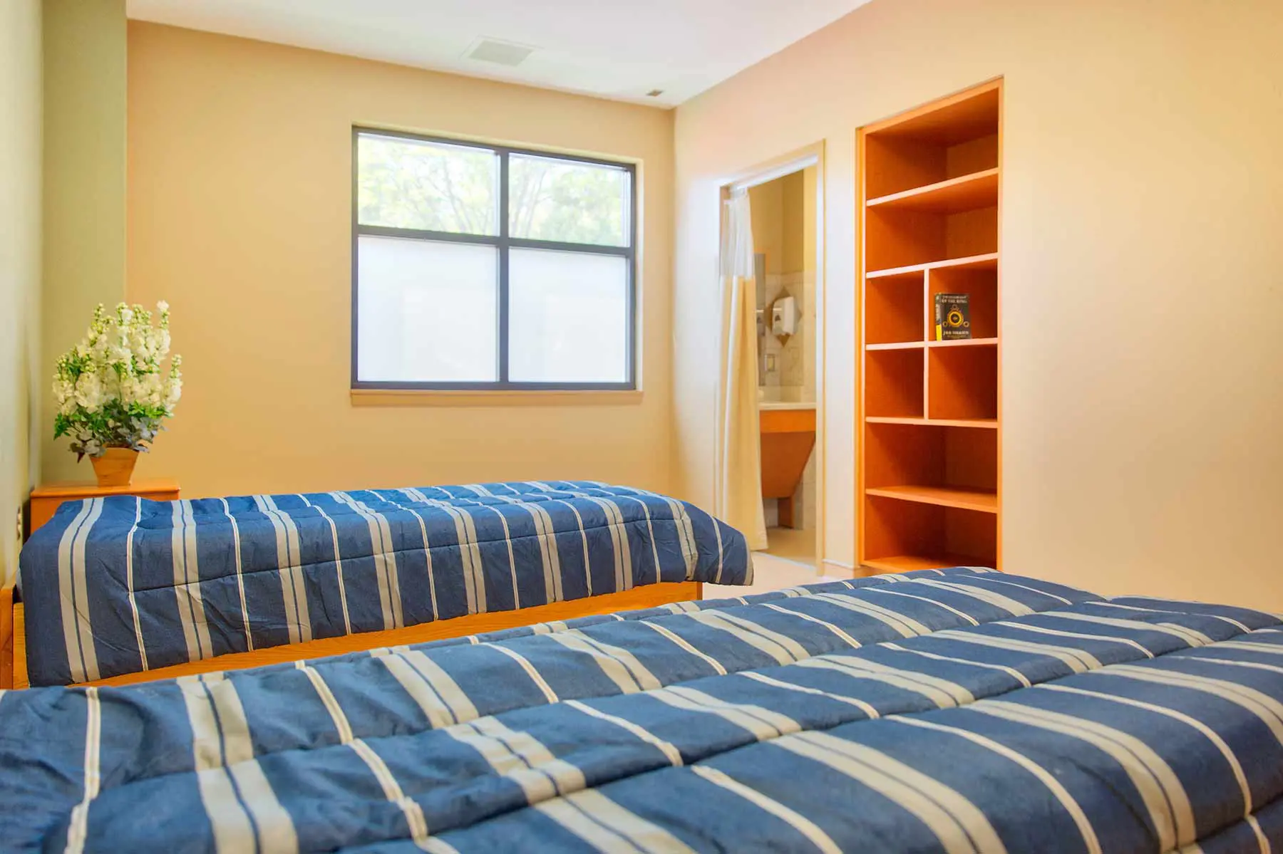 Shared bedroom with two beds and private bathroom entrance