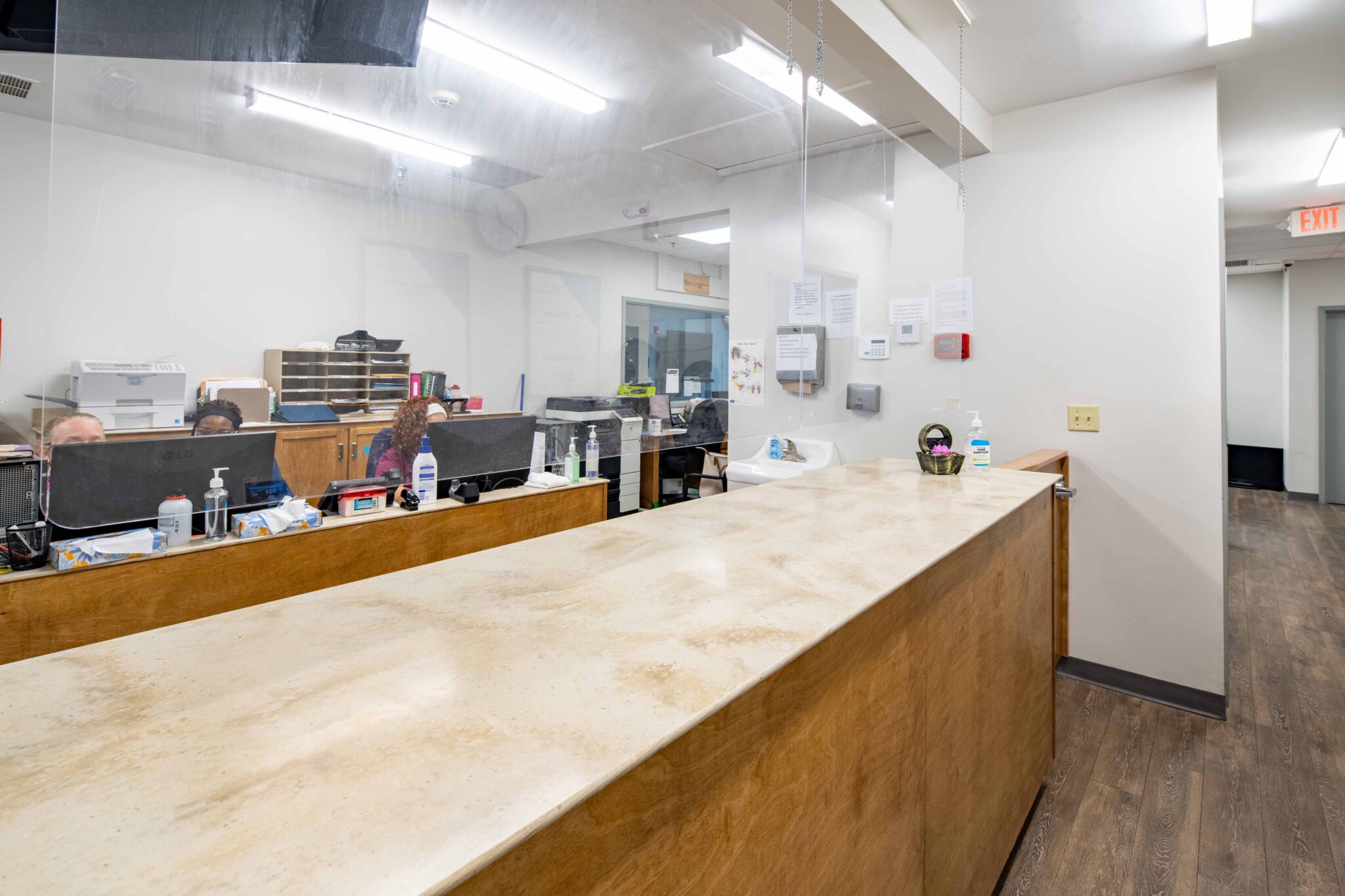 Reception area with long wooden counter and staff workstations