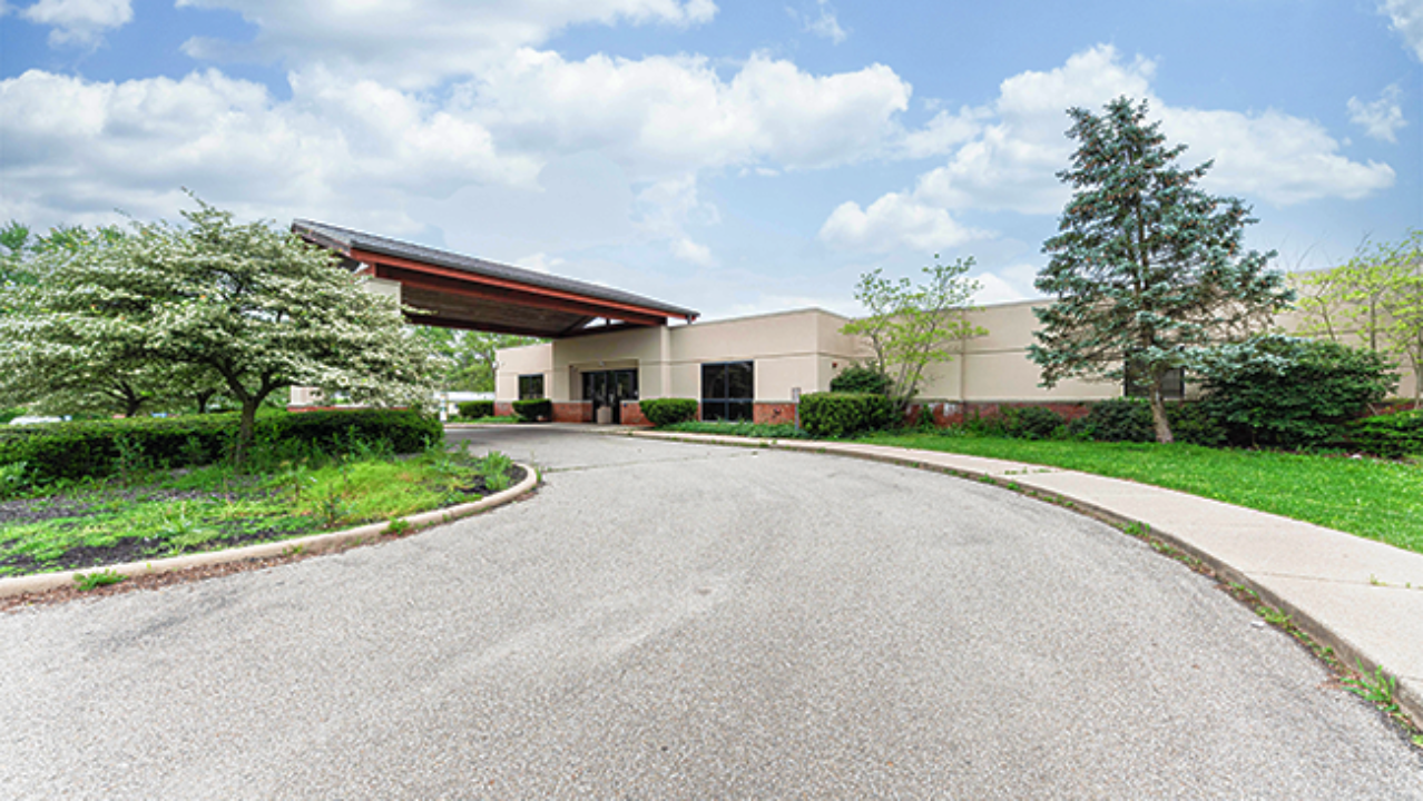 Exterior of BrightView Health Georgetown, Ohio, with covered entrance, landscaped grounds, curved driveway, trees, and a partly cloudy sky