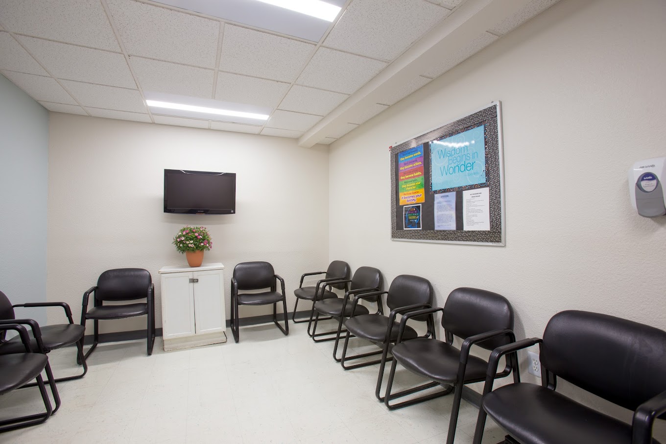 A clean and organized waiting area with comfortable seating, a wall-mounted TV, and uplifting decor, offering a calm and inviting space.
