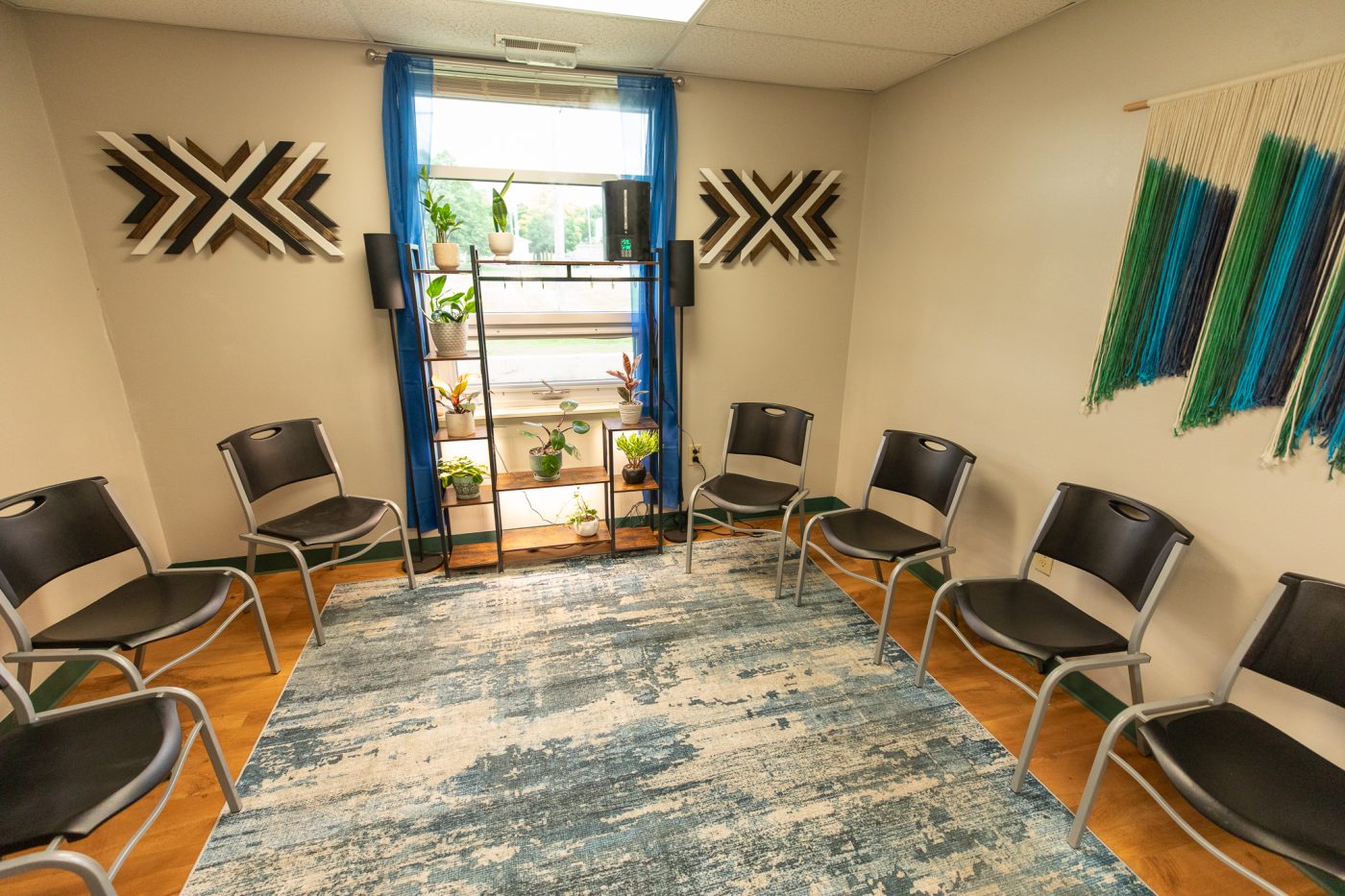 Counseling room with chairs, plants, and calming decor for support group sessions at treatment facility