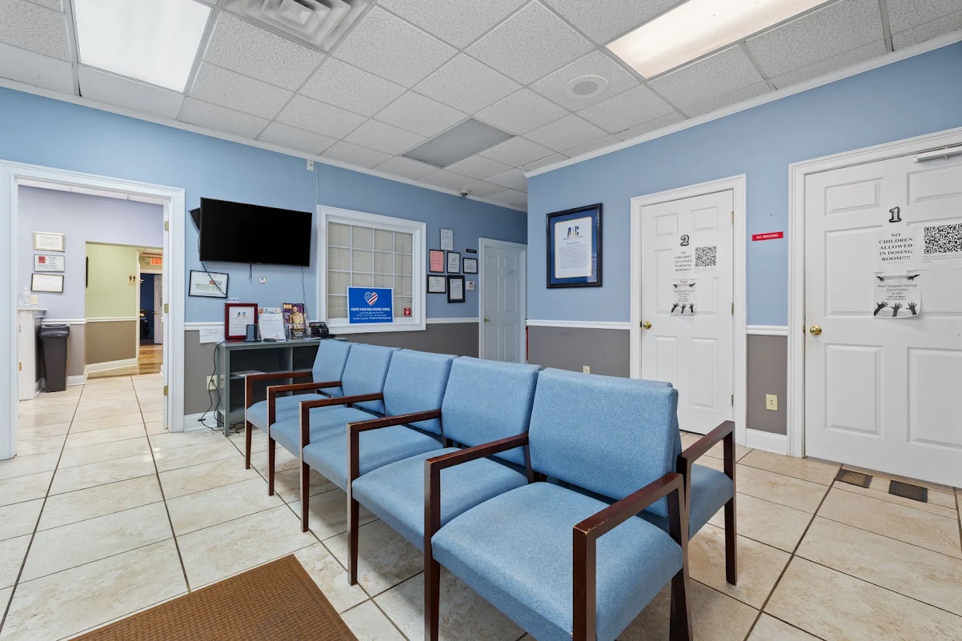 Waiting room with cushioned seating and reception window