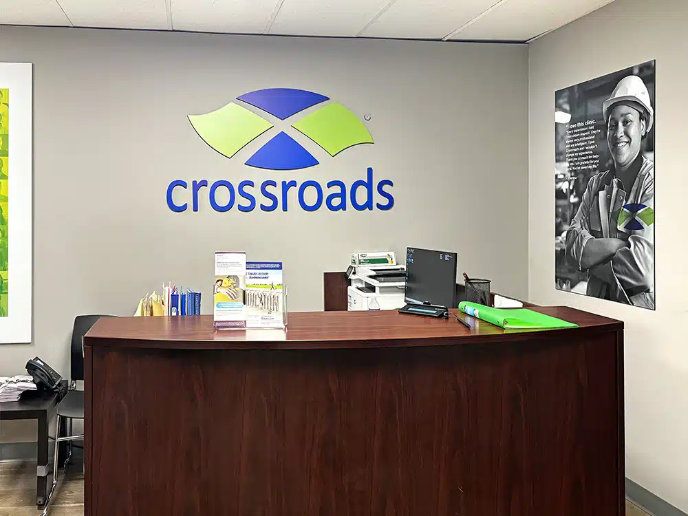 Reception desk with Crossroads logo on wall behind