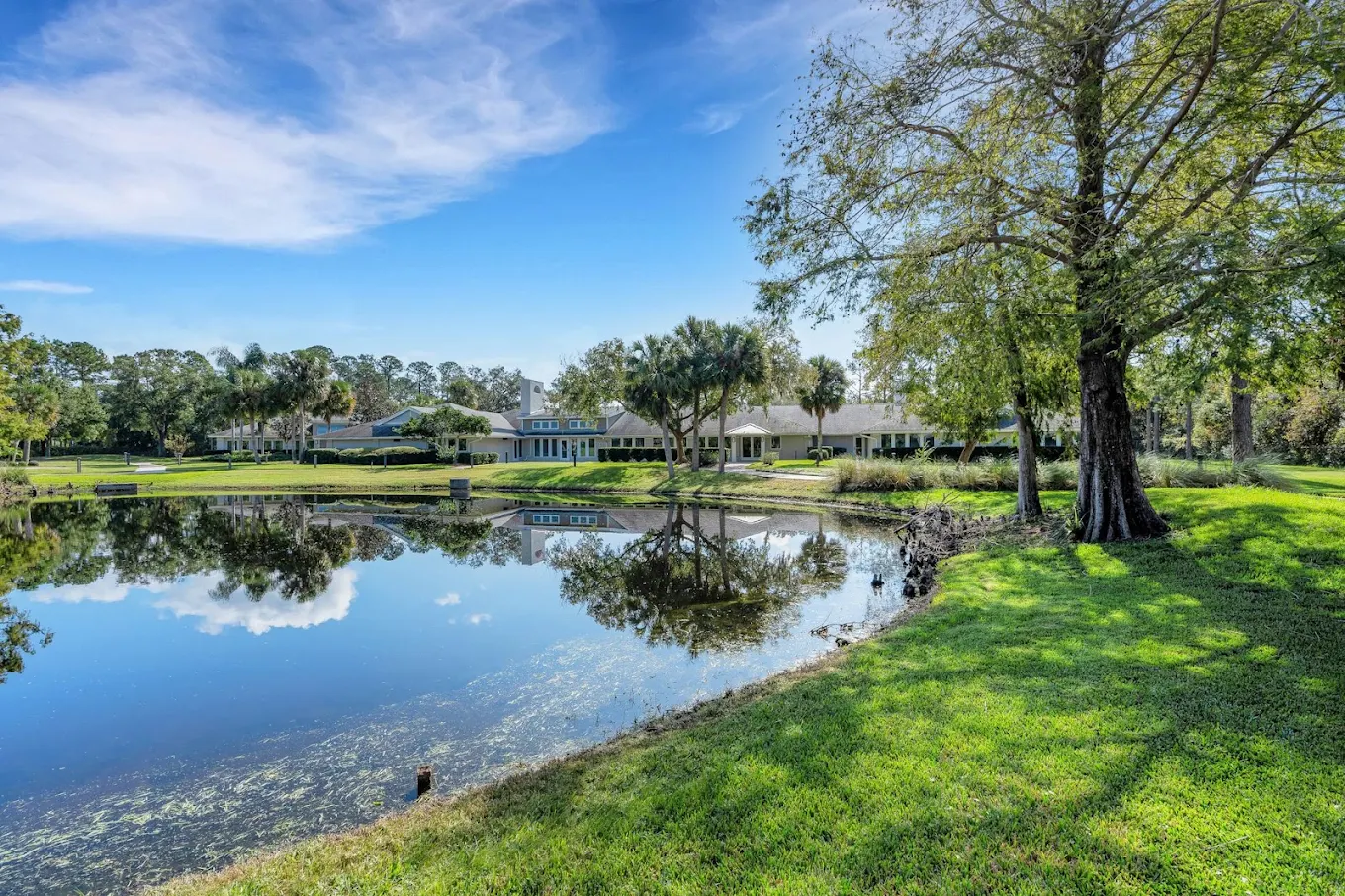 Facility buildings overlooking a pond and grassy grounds