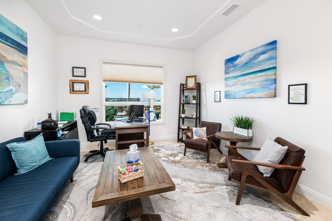 Therapy room with office space and chairs around decor.