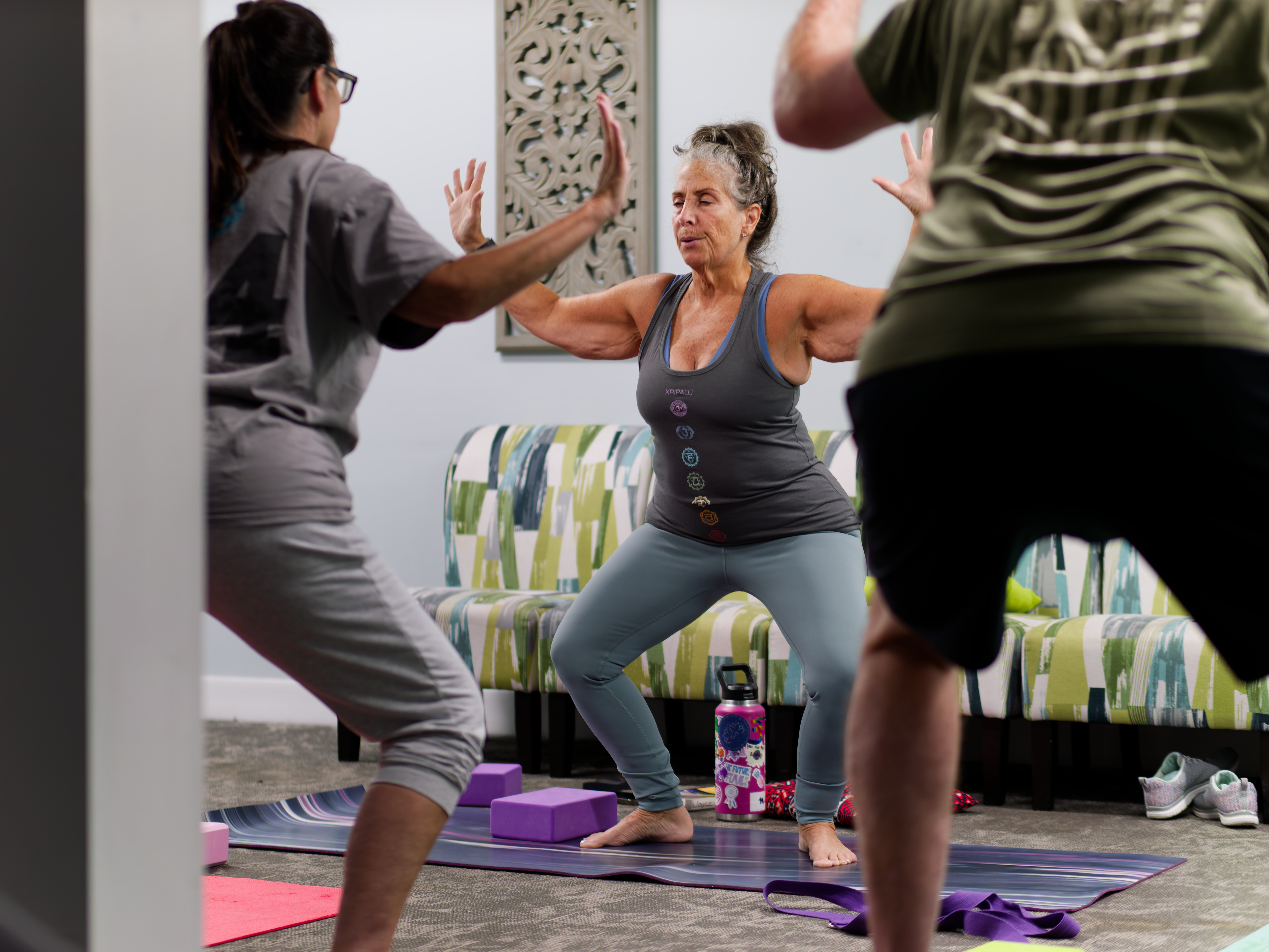 Small group practicing yoga poses in a wellness room.