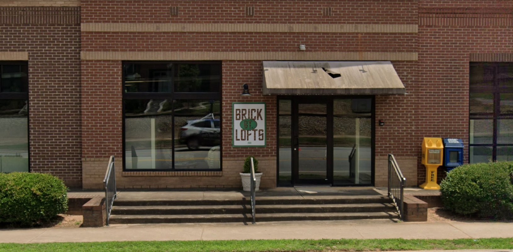 The entrance of a brick building with a sign reading "Brick Lofts"