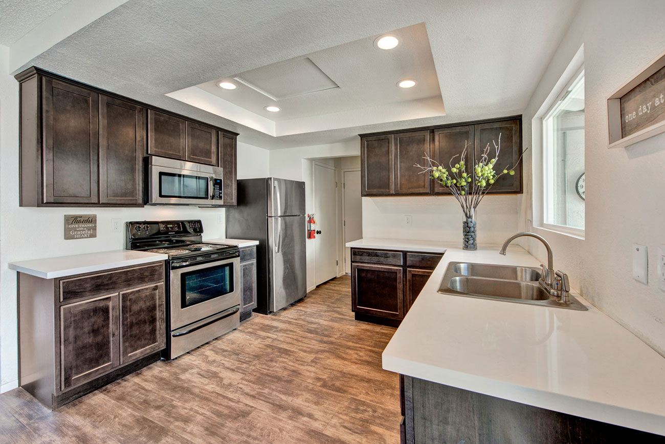 Rehab kitchen with dark cabinets and stainless appliances.