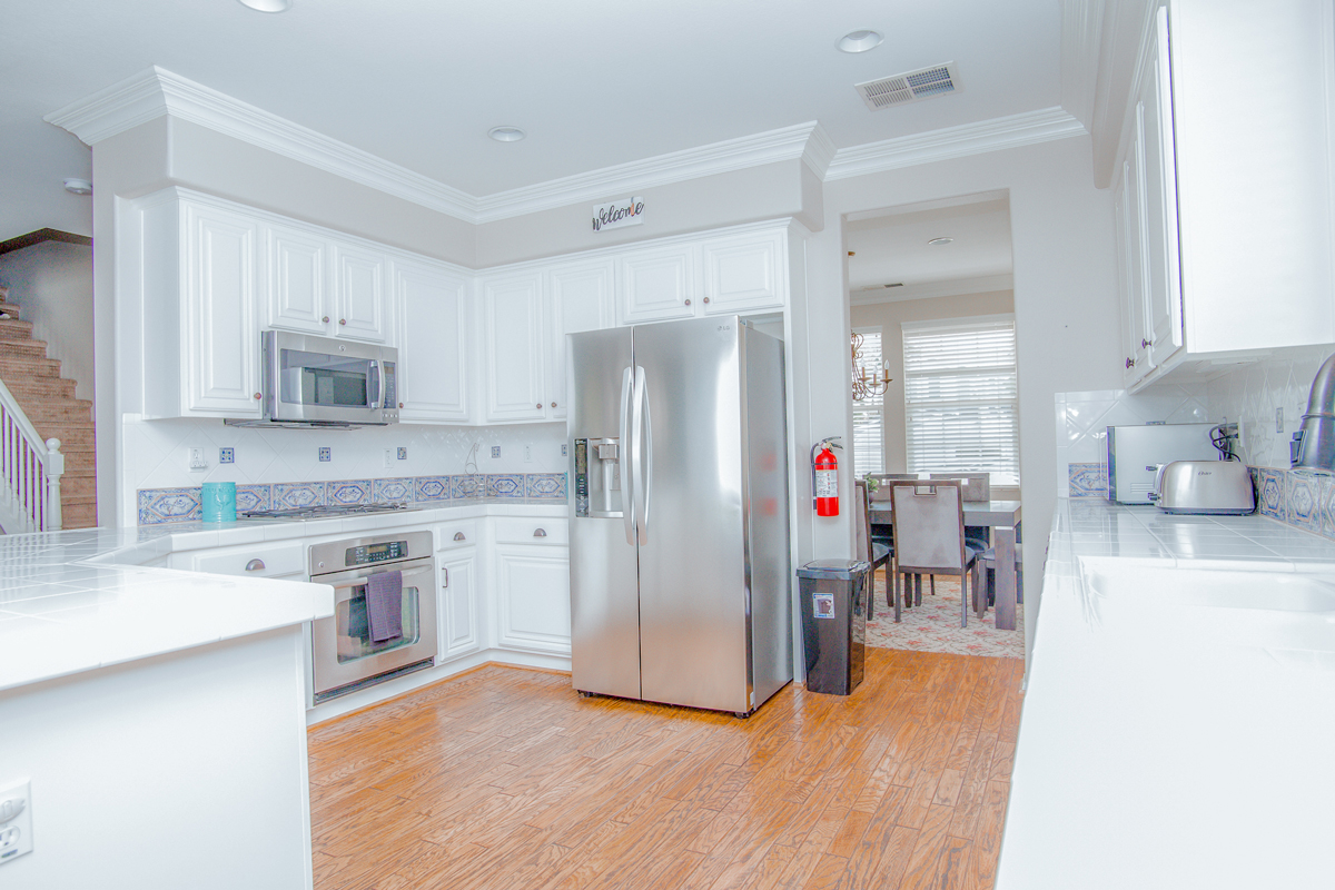 Bright kitchen with white cabinets and stainless appliances