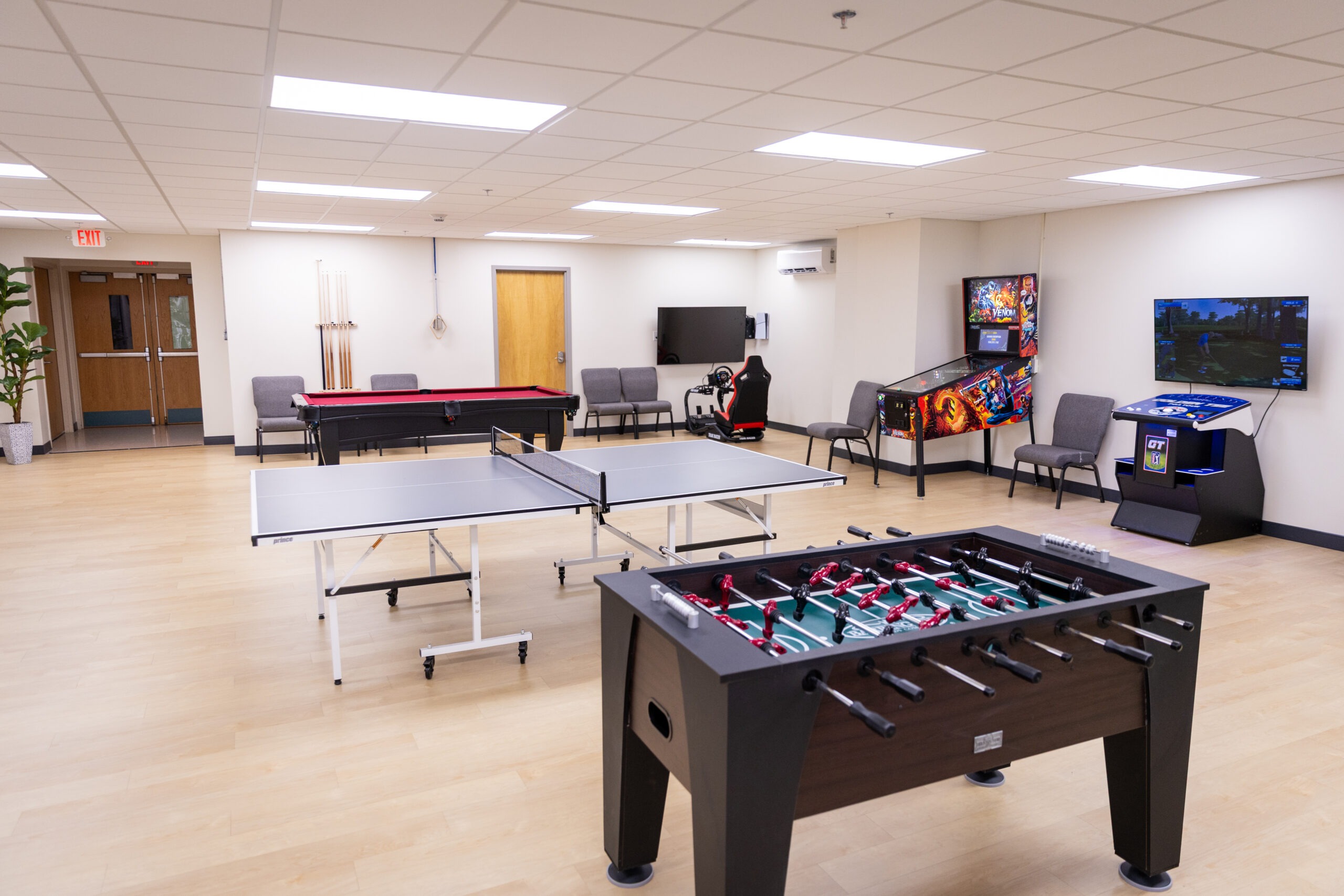 Game room with ping pong, foosball, and arcade machines.