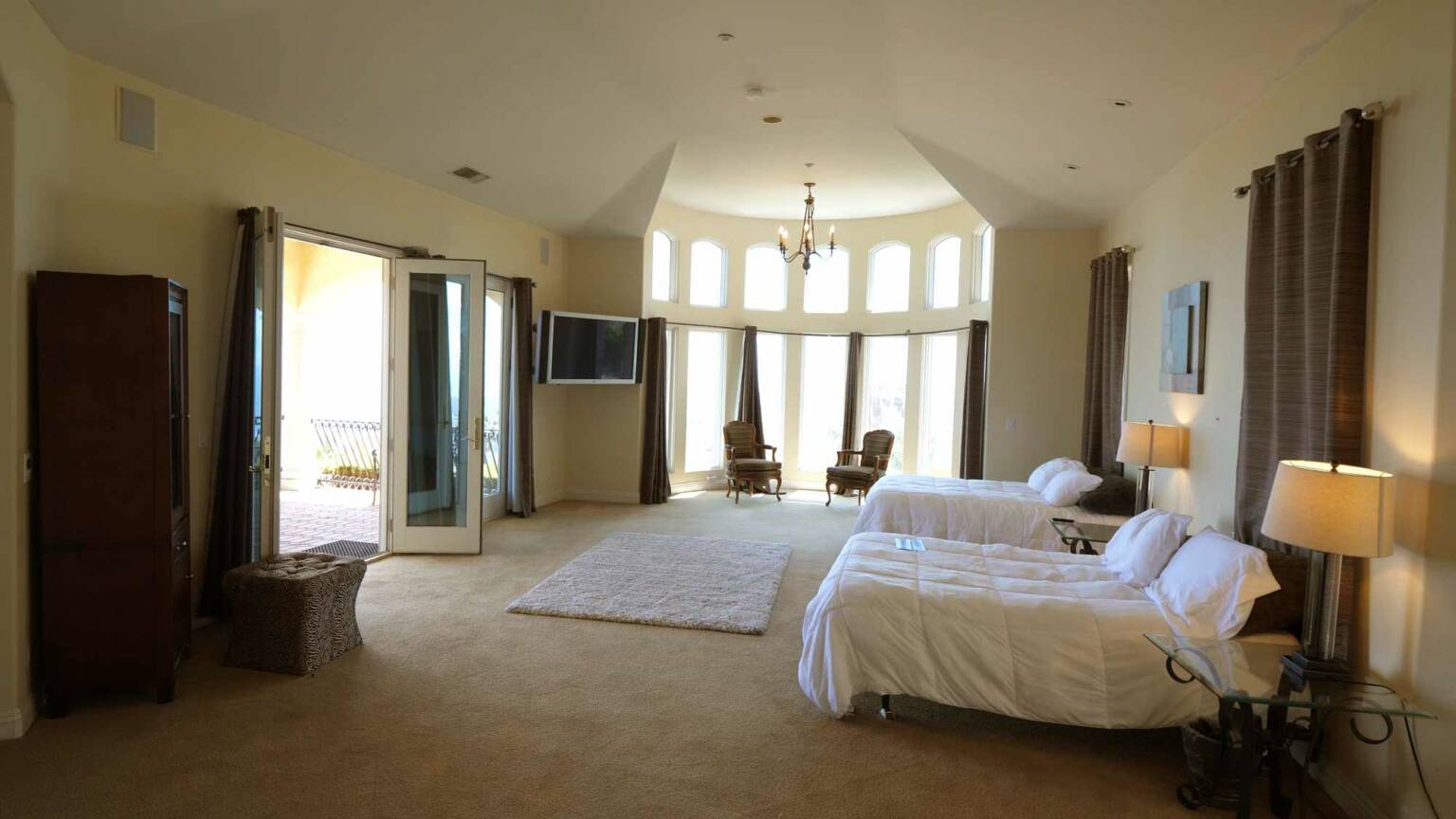 Bright shared bedroom with twin beds and large windows