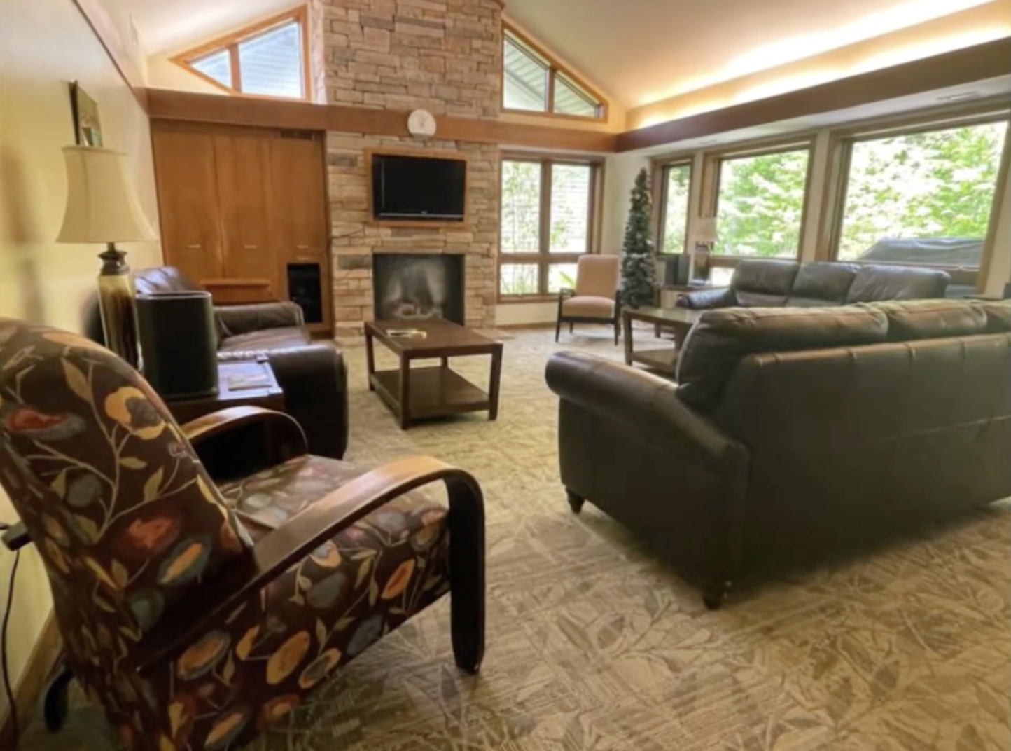 Cozy lounge with sofas, stone fireplace, and large windows