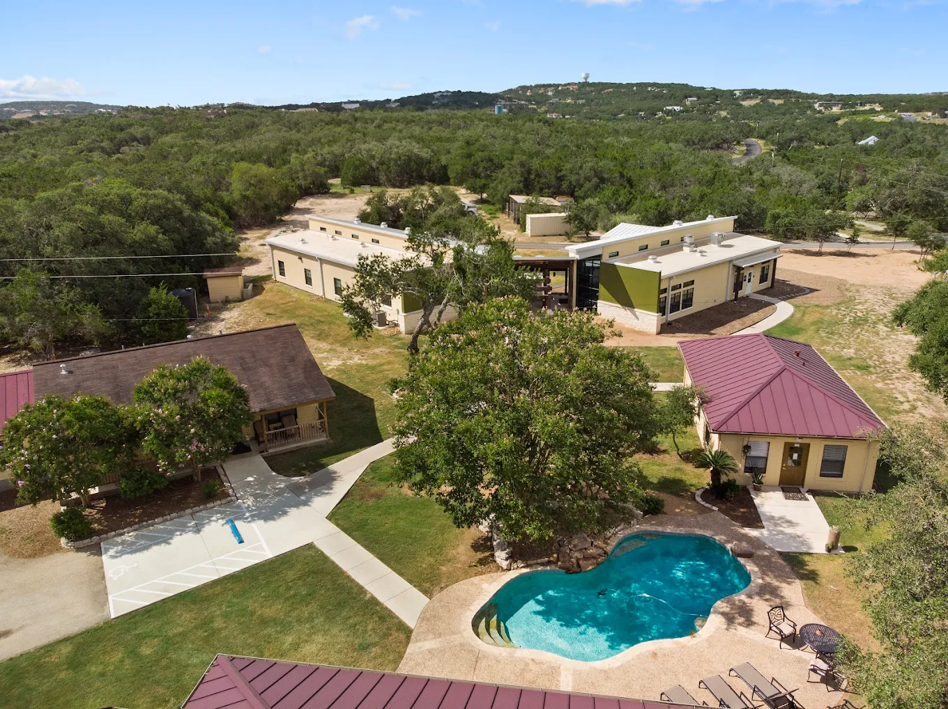 Aerial view of property with pool and buildings