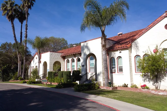 Front exterior of Phoenix House with palm trees and arched windows
