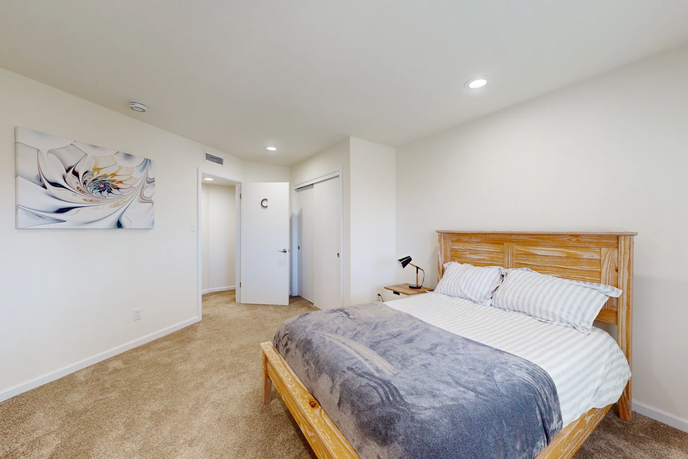 Bed with striped bedding in softly lit bedroom
