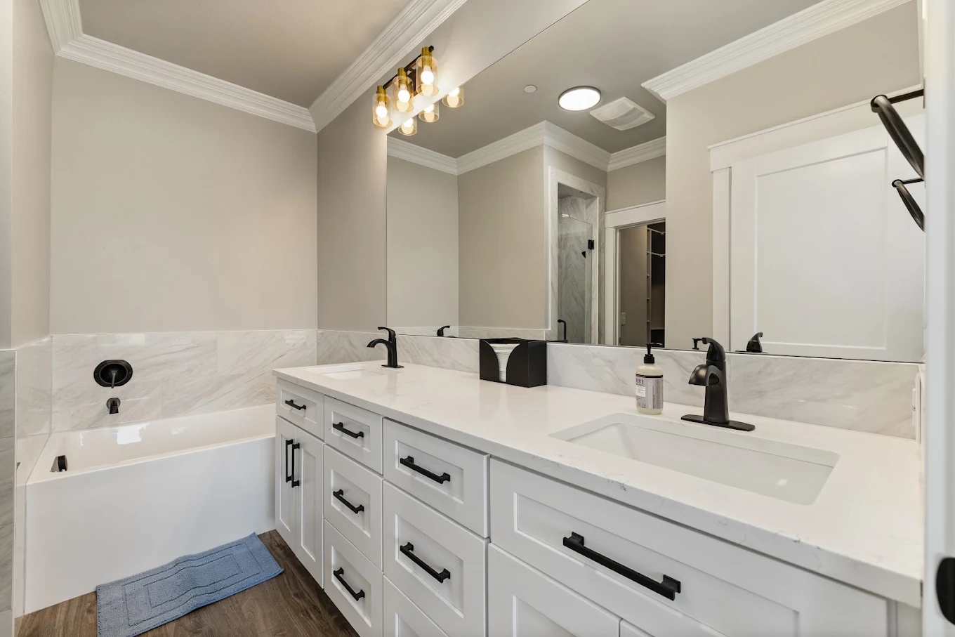 Bathroom with double vanity, bathtub, and walk-in shower