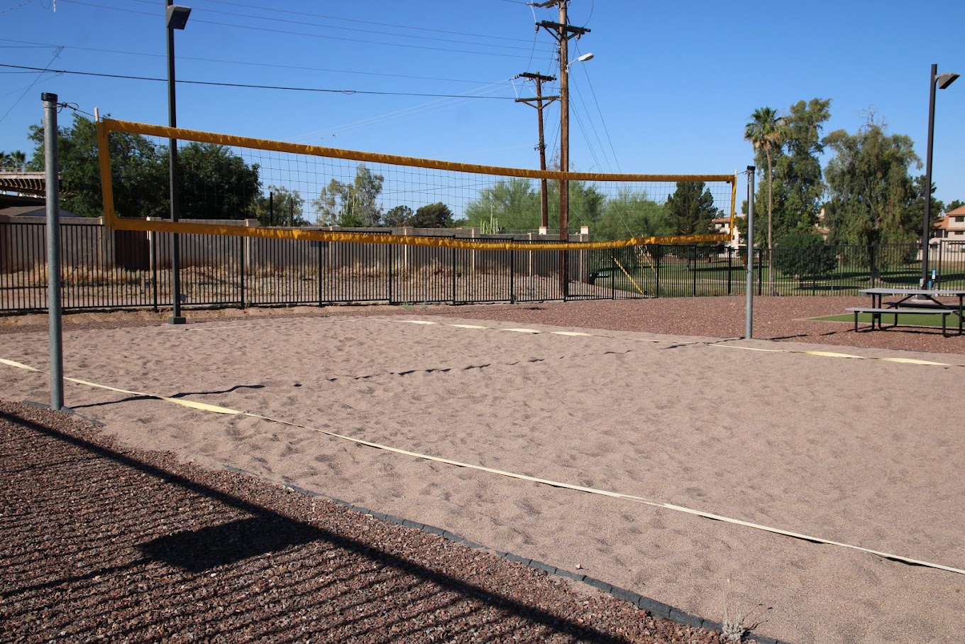 Sand volleyball court with net and benches outside