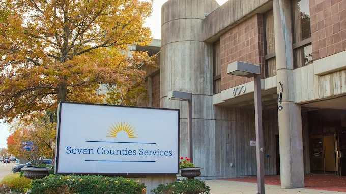 Facility entrance with sign and autumn trees