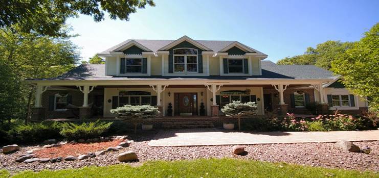 Large two-story house with front porch and landscaped yard