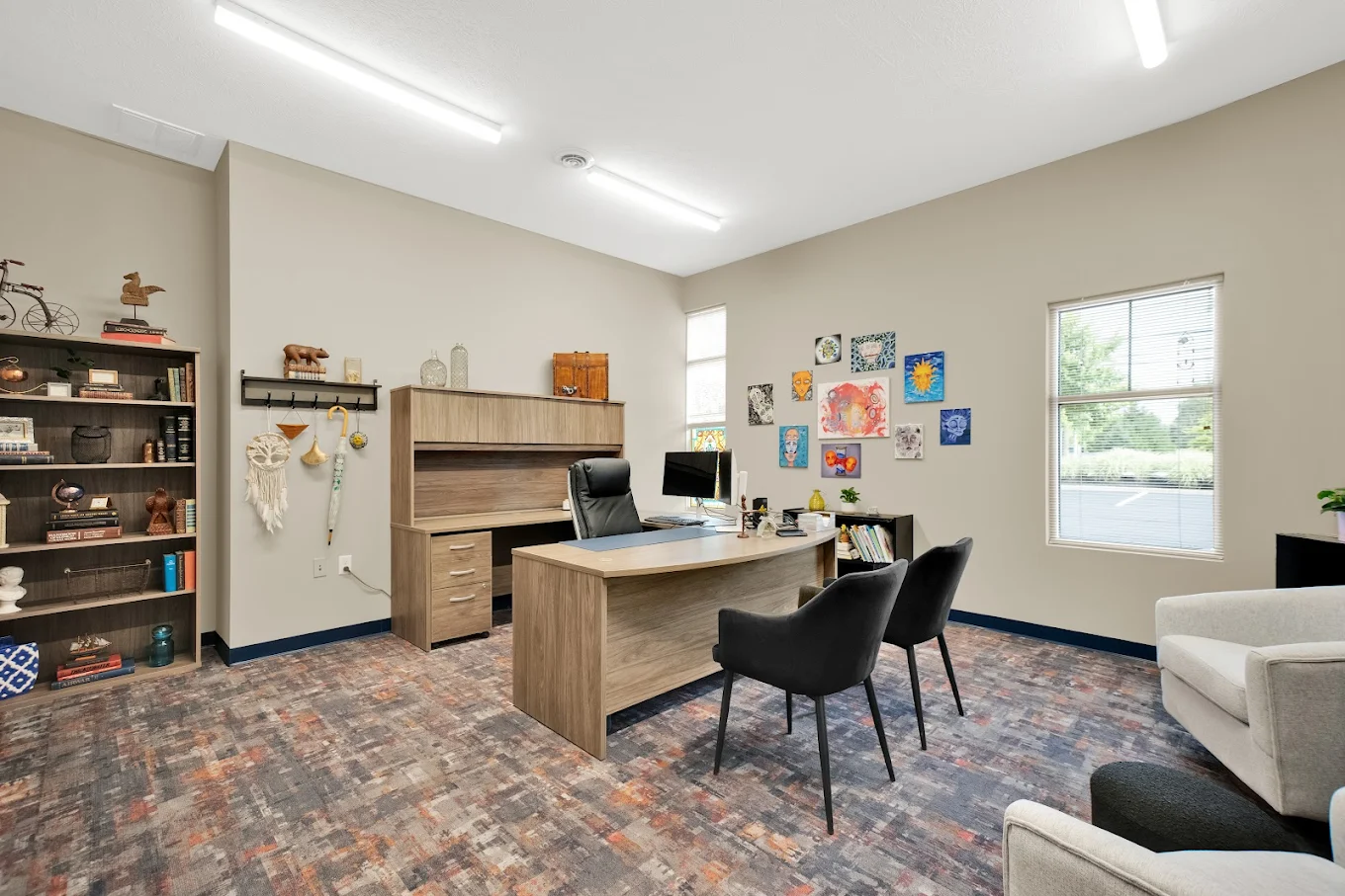 Private office with desk, bookshelf, and guest chairs