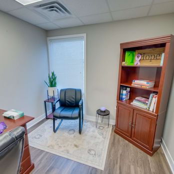 Counseling room with black chair, rug, and bookcase