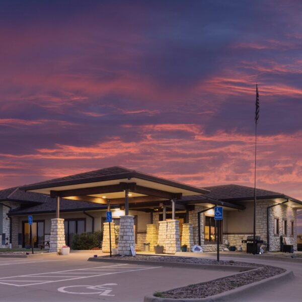 Exterior view of Bel Aire Recovery Center at sunset, showing accessible parking and stone-accented facade