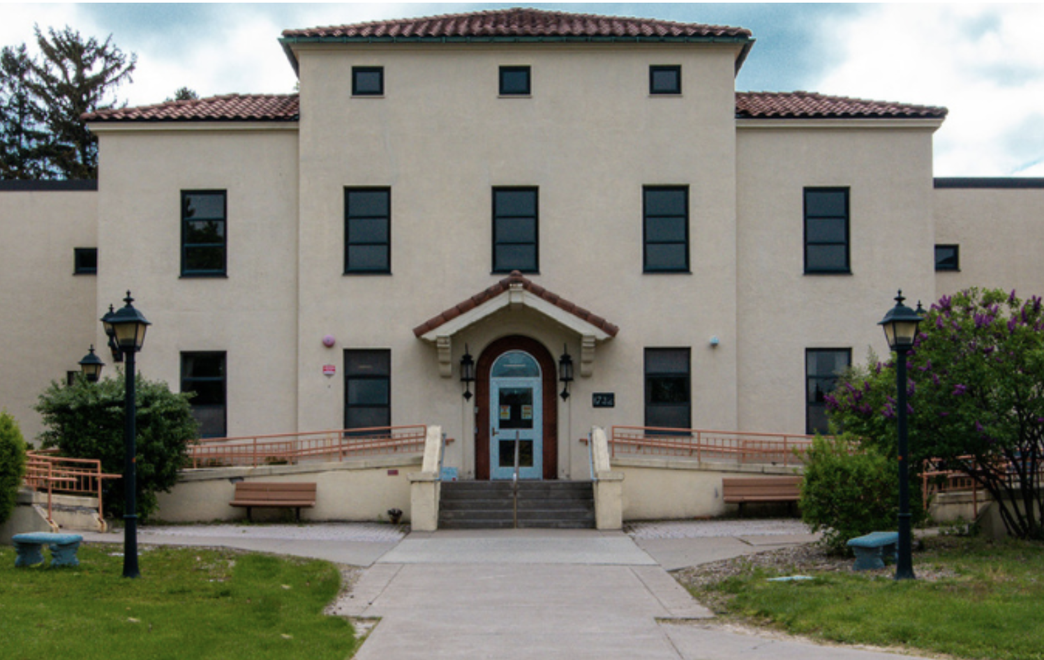 Treatment center entrance with ramps, benches, and landscaping