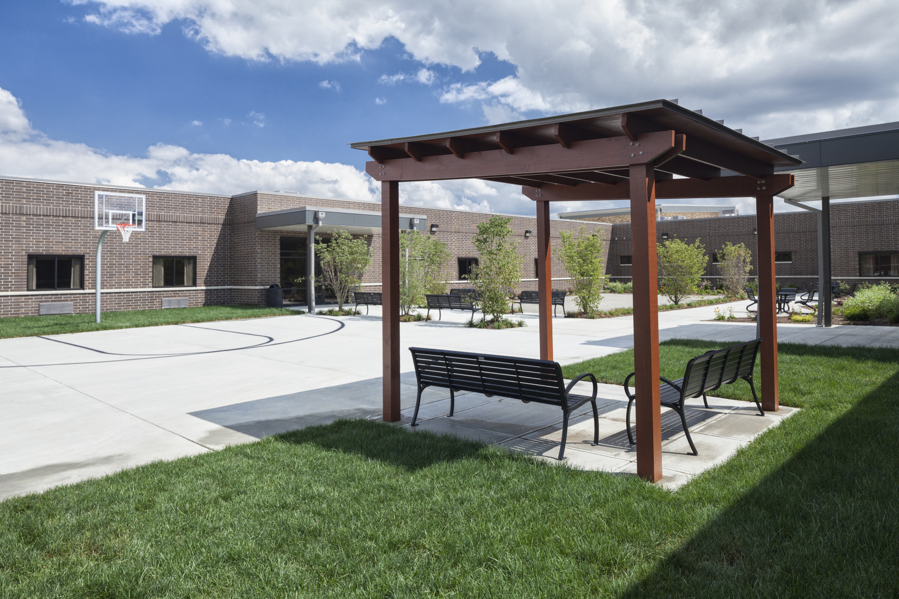 Basketball court with pergola and benches nearby